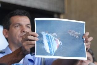 Un officier brésilien montre une photo de l'empennage de l'Airbus A330 repêché dans l'océan Atlantique. (AFP)