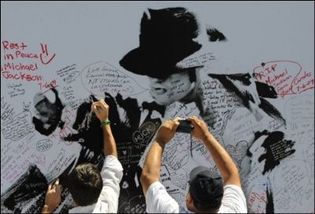 Des fans de Michael Jackson inscrivent des hommages sur le portrait géant de leur idole le 6 juillet 2009 à Staples Center à Los Angeles (Photo: AFP)