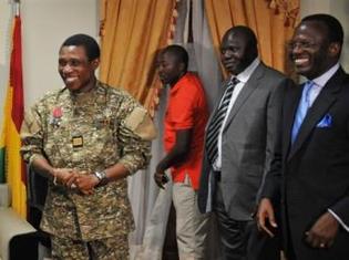 Le chef de la junte guinéenne, Moussa Dadis Camara (g) et le ministre guinéen des Affaires étrangères (1er plan à d), au camp militaire d'Alpha Yaya, à Conakry, le 18 octobre 2009. AFP/Sia Kambou