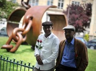 Deux hommes posent devant la sculpture créée par le Français Driss Sans-Arcidet, à la mémoire du Général Dumas, premier général noir dans l’histoire française, à Paris le 10 mai 2009.