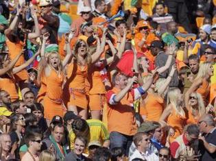 Les fans néerlandais célèbrent la victoire de leur équipe contre le Danemark en Coupe du monde, le 14 juin 2010. Au milieu du groupe, des jeunes femmes portant la tenue incriminée par la FIFA.