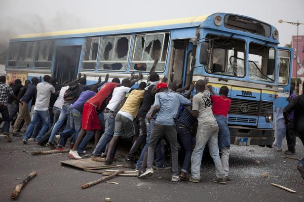 Des manifestants tentent de retourner un bus dans les rues de Dakar (Sénégal), le 1er février 2011 STRINGER / REUTERS