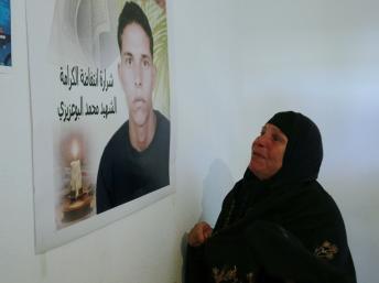 La mère de Mohamed Bouazizi devant un portrait de son fils. REUTERS/Louafi Larbi