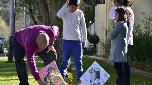 Une famille devant la maison de Nelson Mandela à Johannesburg, le 9 juin 2013. REUTERS/Mujahid Safodien