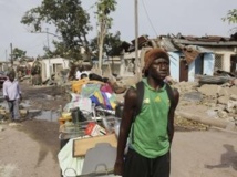 Un habitant déplace ses effets personnels du quartier de Mpila, touché dimanche 4 mars par une série d'explosions dans une dépôt de munitions. REUTERS/Jonny Hogg