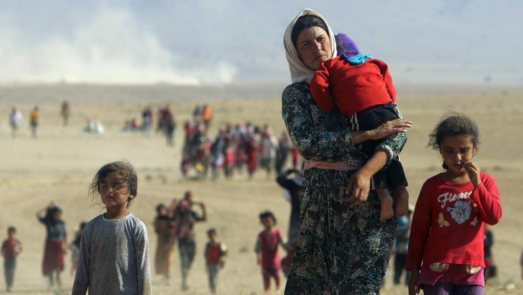 Des Irakiens de la minorité Yezidi fuient les combats entre le groupe Etat islamique et l'armée irakienne dans la ville de Sinjar, le 11 août 2014. REUTERS/Rodi Said/Files