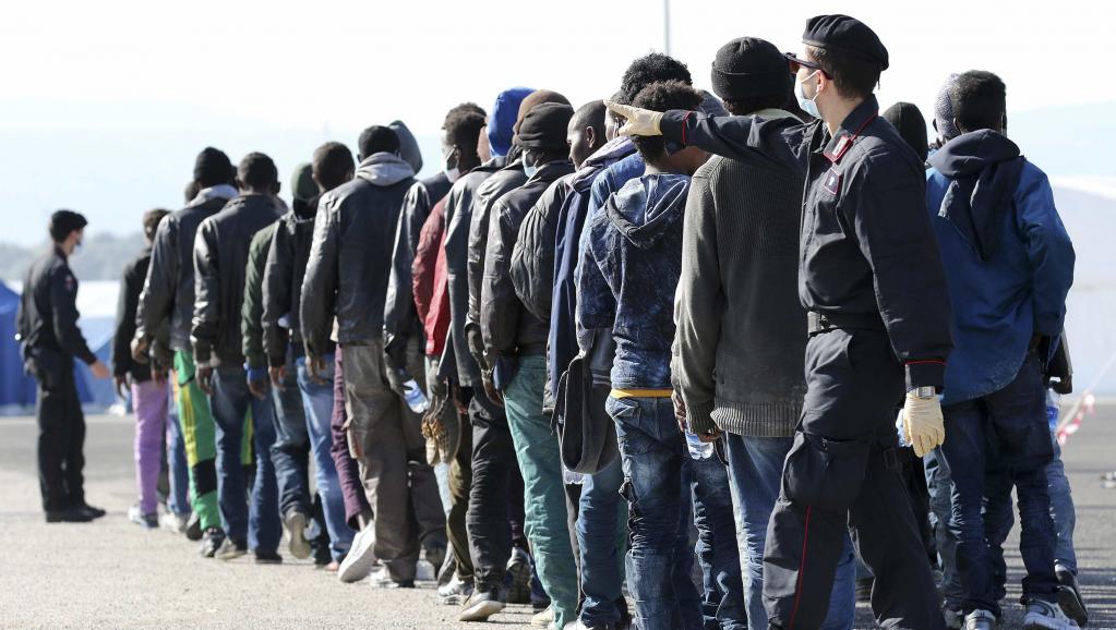 Des migrants sont regroupés par les autorités italiennes après avoir débarqué dans le port d'Augusta, en Sicile, le 17 janvier 2015.